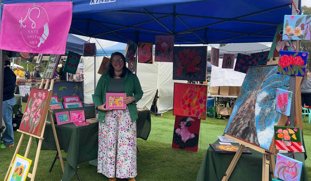 Kate Smith at her Kate Smith Art market stall surrounded by her paintings
