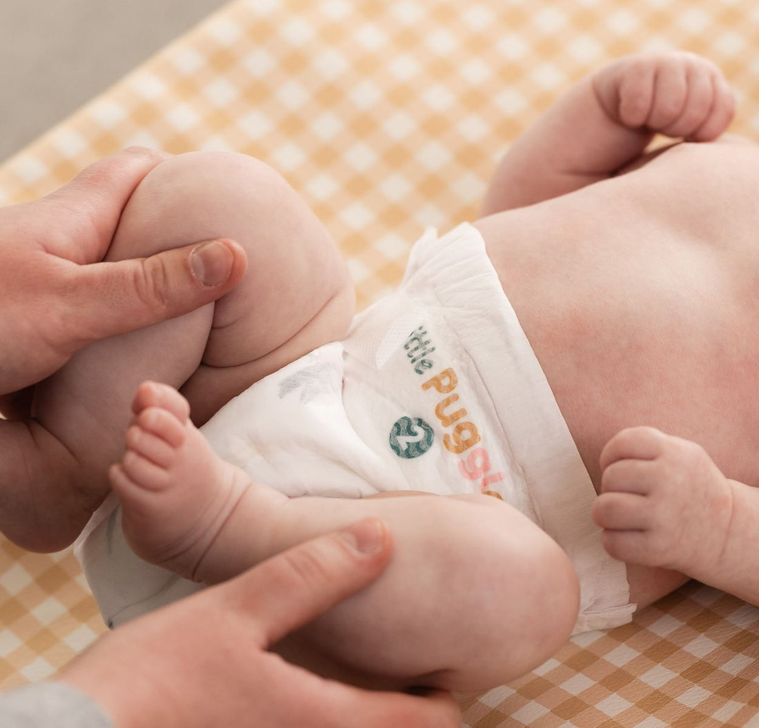 A baby with deep thigh creases, the leg cuff drawn down into the fold rather than resting on top of the thigh roll
