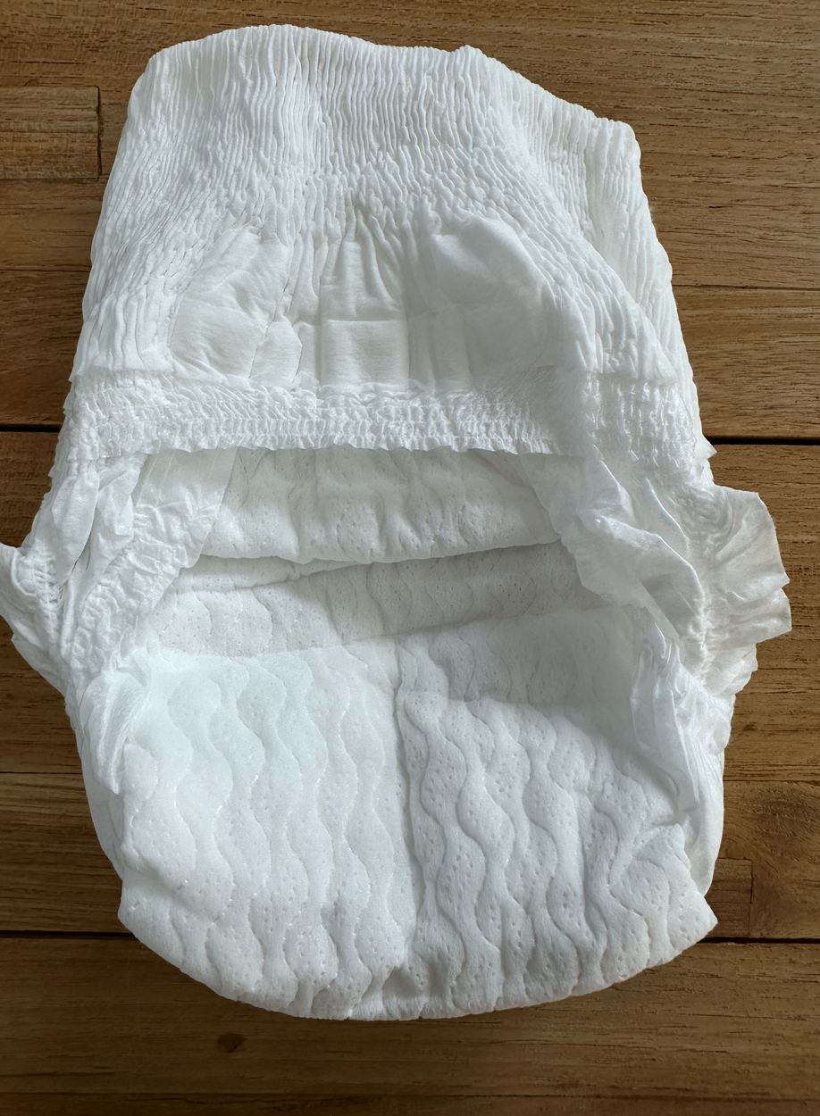 Back of a Little Puggles nappy pant laid flat, showing the gathered back pocket